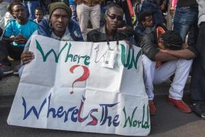 Protestors hold a sign as thousands of African asylum …