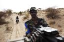 A Malian soldier holds a machine gun mounted on a pick-up truck during a military escort outside Timbuktu