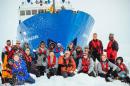 Image taken by Andrew Peacock on December 28, 2013 shows passengers posing for a photo with the MV Akademik Shokalskiy, which is trapped in the ice at sea off Antarctica