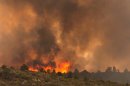 Flames top a ridge as the Yarnell Hill Fire moves towards Peeples Valley, Ariz. on Sunday, June 30, 2013. The fire started Friday and picked up momentum as the area experienced high temperatures, low humidity and windy conditions. It has forced the evacuation of residents in the Peeples Valley area and in the town of Yarnell. (AP Photo/The Arizona Republic, Tom Story)