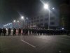 In this Monday Sept. 24, 2012 mobile phone photo, police in anti-riot suits cordon off a road near Foxconn's plant in Taiyuan, capital of Northern China's Shanxi province. The company that makes Apple's iPhones suspended production at a factory in China on Monday after a brawl by as many as 2,000 employees at a nearby dormitory injured 40 people. The facility will reopen Tuesday. (AP Photo) CHINA OUT