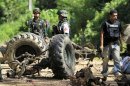 Thai security personnel inspect the wreckage of a military truck after a bomb attack by suspected Muslim militants on a roadside in Yala province