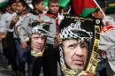 Palestinian youth hold portraits of late Palestinian leader Yasser Arafat during a march in the West Bank town of Hebron on November 11, 2013 to mark the ninth anniversary of Arafat's death