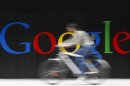 File photo of an employee riding her bike past a logo next to the main entrance of the Google building in Zurich