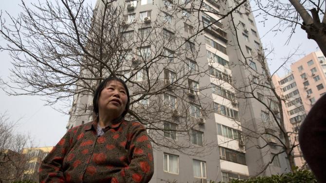 In this photo taken Monday, March 16, 2015, Chen Shuhong is interviewed in front of the residential compound where she rents out apartments as housing for cancer patients in Beijing.  These so-called cancer hotels that dot the neighborhood around China&#39;s most renowned cancer hospital, give patients an affordable, cozy place to wait for appointments and undergo outpatient treatment. (AP Photo/Ng Han Guan)