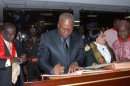 Ghana's Vice President John Dramani Mahama (C) signs documents after taking the oath of office as head of state