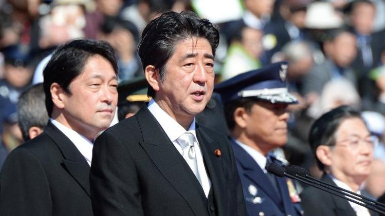 Japanese Prime Minister Shinzo Abe (C) delivers a speech next to Defence Minister Itsunori Onodera (L) during military review at the Ground Self-Defence Force's Asaka training ground, on October 27, 2013