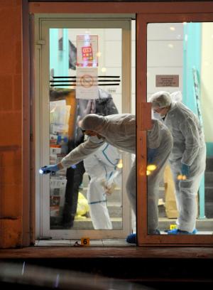Forensic officers collect evidence outside the police &hellip;