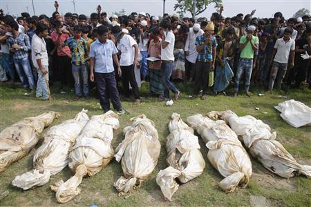 Bodies of unidentified garment workers, who died in the collapse of the Rana Plaza building in Savar, lie on the ground as people gather to watch a mass burial in Dhaka May 1, 2013. REUTERS/Andrew Biraj