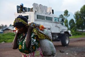 A Congolese woman walks past an armoured vehicle of …