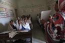 A teacher displays a flash card to students in Johi