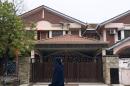 A Muslim woman walks past the missing Malaysia Airlines co-pilot Fariq Abdul Hamid's house in Shah Alam, outside Kuala Lumpur, Malaysia, Friday, March 14, 2014. The pilots of the missing Malaysia Airlines passenger jet were a contented middle-aged family man passionate enough about flying to build his own simulator and the 27-year-old contemplating marriage who had just graduated to the cockpit of the Boeing 777. Details about the men have emerged from interviews with neighbors, Malaysia Airlines staff, a religious leader and from social networks and news reports in Malaysia and Australia. (AP Photo/Lai Seng Sin)