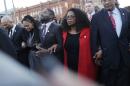 Oprah Winfrey locks arms with David Oyelowo, left, who portrays Martin Luther King Jr. in the movie "Selma," Ava DuVernay, the director of "Selma" and rapper Common, far left, as they march to the Edmund Pettus Bridge in honor of Martin Luther King Jr., Sunday, Jan. 18, 2015, in Selma, Ala. (AP Photo/Brynn Anderson)