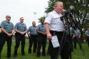 Ferguson Police Chief Tom Jackson is surrounded by his officers as he answers questions at a news conference in Forestwood Park on Friday, Aug. 15, 2014. Jackson took questions in the quiet park after earlier identifying Darren Wilson as the officer who shot Michael Brown. (AP Photo/St. Louis Post-Dispatch, Robert Cohen)