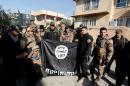 Lieutenant General Abdelwahab al-Saadi and members of Iraqi Counter Terrorism Forces hold an Islamic State flag which they pulled down during a battle with Islamic State militants, east of Mosul