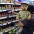 A customer holds a child while shopping at a supermarket in Shenyang