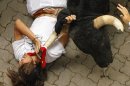 A reveler is tossed by a Dolores Aguirre Yabarra ranch fighting bull during the running of the bulls of the San Fermin festival, in Pamplona Spain, Saturday, July 7, 2012. (AP Photo/Daniel Ochoa de Olza)