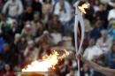Greek actress Menegaki raises an Olympic torch of the Sochi 2014 Winter Games during a handover ceremony at the Panathenean stadium in Athens