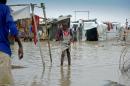 A young girl walks through a heavily flooded part of the Tomping camp for internal refugees after heavy rains started to fall in Juba on March 13, 2014