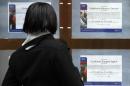 A woman looks at job advertisements in a the window of a recruitment agency in Manchester, northwest England, on January 12, 2009