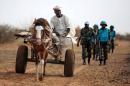 A picture taken on July 1, 2014 and released by the United Nations-African Union Mission in Darfur (UNAMID) on July 2, 2014, shows a farmer in Karbab, South Darfur, in his cart while UNAMID troops from Tanzania arrive to patrol the Sudanese village