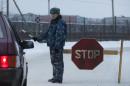 A prison service officer stops a car on the road at the prison where Mikhail Khodorkovsky was kept in Segezha, near Petrozavodsk, Russia, Friday, Dec. 20, 2013. Russia's once richest man Mikhail Khodorkovsky, the arch rival of President Vladimir Putin, has been released from prison after a decade behind bars, his spokeswoman told the Associated Press on Friday. Khodorkovsky spent 10 years in prison on politically tinted charges of tax evasion and embezzlement. (AP Photo/Ivan Sekretarev)