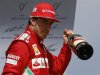 Ferrari Formula One driver Alonso of Spain holds a bottle of champagne after winning the German F1 Grand Prix at the Hockenheimring