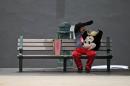 A street performer in a Mickey Mouse costume rests on a bench in Old San Juan, Puerto Rico, Wednesday, July 1, 2015, the day a 11.5% sales tax went into effect, the highest of any U.S. state. The island's administration has been pushing for Congress to let the government and public agencies seek bankruptcy protection, while the White House has said no one is contemplating a federal bailout of Puerto Rico. (AP Photo/Ricardo Arduengo)