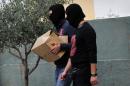 Anti-terror police bring a box containing the case file against an arrested extreme far-right Golden Dawn party member to an Athens court on October 2, 2013