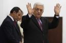 Palestinian President Mahmoud Abbas waves during a swearing-in ceremony of the unity government, in the West Bank city of Ramallah