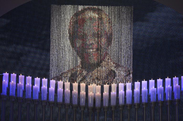 Candles are lit under a portrait of Nelson Mandela before his funeral in his boyhood village of Qunu on December 15, 2013