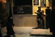 A penitent walks past a statue of Elvis Presley placed outside a bar as he leaves the procession of "Salesianos" brotherhood during Holy Week in the An dalusian city of Malaga, southern Spain, April 20, 2011. REUTERS/Jon Nazca