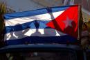 Children's shadows are cast on a Cuban national flag as they take part in a caravan tribute marking the 56th anniversary of the original street party that greeted a triumphant Castro and his rebel army, in Regla, Cuba, Thursday, Jan. 8, 2015. Castro and his rebels arrived in Havana via caravan on the first week of January 1959, after toppling dictator Fulgencio Batista. The revolutionary leader and former president has not spoken publicly on the historic Dec. 17th US-Cuba detente. (AP Photo/Ramon Espinosa)