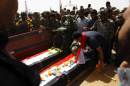 Iraqi Shiite mourners prepare coffins during the funeral of 12 fighters killed fighting the Islamic State group, in the city of Najaf on September 25, 2014