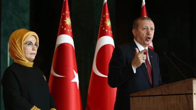 Turkish President Recep Tayyip Erdogan delivers a speech, flanked by his wife Emine, at the Presidential Palace in Ankara on February 9, 2016