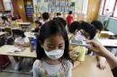 An elementary school student wearing a mask to prevent contracting Middle East Respiratory Syndrome (MERS), receives a temperature check at an elementary school in Seoul
