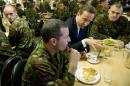 Prime Minister David Cameron (2nd right) eats lunch with British soldiers during a visit to Wellington Barracks in central London on October 14, 2010