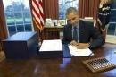 President Barack Obama signs the budget bill in the Oval Office of the White House, Friday, Dec. 18, 2015, in Washington. (AP Photo/Carolyn Kaster)