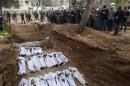 Syrian mourners pray over the bodies of civilians during their mass burial in the Bustan al-Qasr district of Aleppo, on January 31, 2013