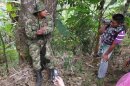 An indigenous man films a member of FARC at an illegal check point near the entrance to Toribio