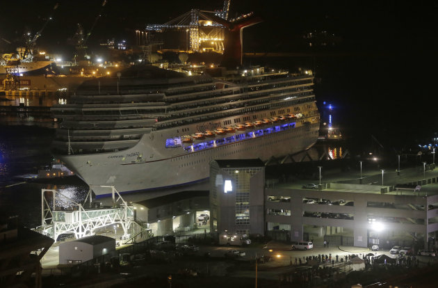 <p>               The cruise ship Carnival Triumph is pushed towards the cruise terminal along the Mobile River in Mobile, Ala., Thursday, Feb. 14, 2013. The ship with more than 4,200 passengers and crew members was idled for nearly a week in the Gulf of Mexico following an engine room fire. (AP Photo/Dave Martin)