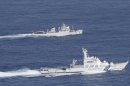 In this photo released by Japan Coast Guard, a Japan Coast Guard vessel, bottom, sails along with a Chinese fisheries patrol boat near disputed islands, called Senkaku in Japan and Diaoyu in China, in the East China Sea Tuesday, Sept. 18, 2012. The Coast Guard vessel issued a warning to the vessel near the islands early Tuesday. (AP Photo/Japan Coast Guard)
