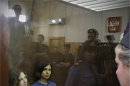 Feminist punk group Pussy Riot members, from left, Maria Alekhina and Nadezhda Tolokonnikova sit in a glass cage at a court room in Moscow, Russia on Friday, Aug. 17, 2012. A judge found three members of the provocative punk band Pussy Riot guilty of hooliganism on Friday, in a case that has drawn widespread international condemnation as an emblem of Russia's intolerance of dissent. T-shirt on right worn by Tolokonnikova is Spanish and translates to "They shall not pass", a slogan often used to express determination to defend a position against an enemy. (AP Photo/Sergey Ponomarev)