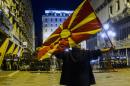 A protestor waves a Macedonian flag in front of anti-riot police in Skopje on April 14, 2016