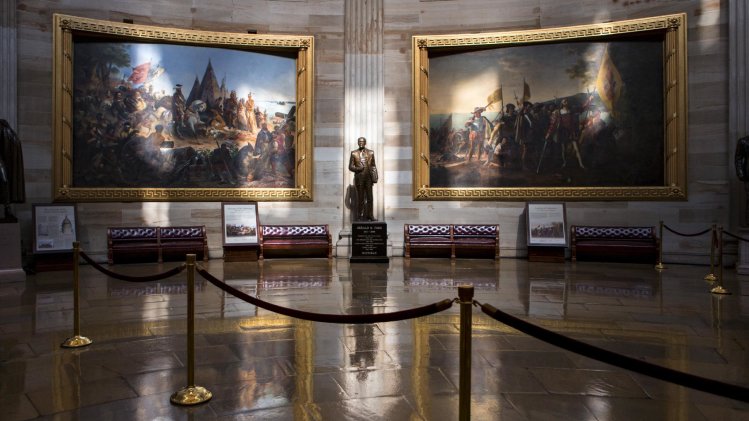 Normally filled with visitors and tourists, the empty Rotunda at the U.S. Capitol is seen in Washington, Tuesday, Oct. 1, 2013, after officials suspended all organized tours of the Capitol and the Capitol Visitors Center as part of the government shutdown. A statue of President Gerald R. Ford at center is illuminated amid large paintings illustrating the history of the United States. (AP Photo/J. Scott Applewhite)