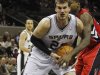 Spurs' Splitter gets tied up by Raptors' Davis during the second half of their NBA basketball game in San Antonio