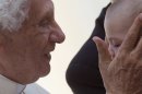 Pope Benedict XVI blesses blesses a baby at the end of his weekly general audience, in St. Peter's Square at the Vatican, Wednesday, Oct. 24, 2012. Benedict has named six new cardinals, adding prelates from Lebanon, the Philippines, Nigeria, Colombia, India and the United States to the ranks of cardinals who will elect his successor. He made the surprise announcement during the audience and said they would be elevated at a consistory Nov. 24. (AP Photo/Andrew Medichini)