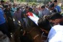 Jordanian mourners lower the body of an intelligence officer killed during a gun attack at the Palestinian refugee camp of Baqaa, north of Amman, on June 6, 2016